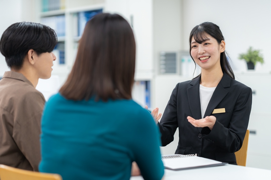 明るい室内でスタッフがお客様のお部屋探し相談に対応している様子